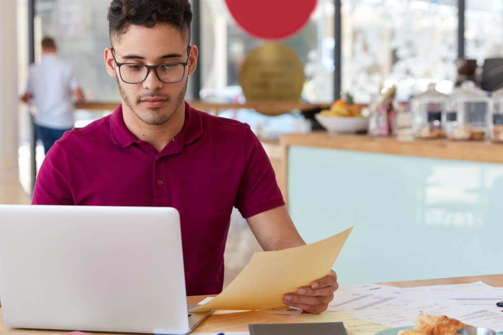 Hombre joven utilizando computador portatil en su trabajo